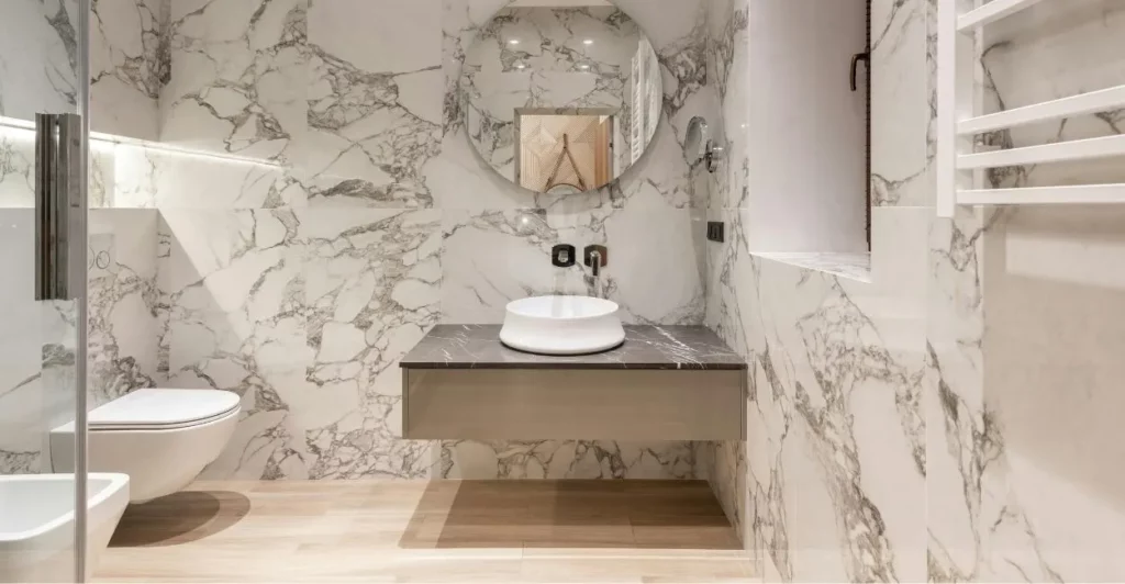 Banheiro moderno com acabamento em mármore branco em Goiânia