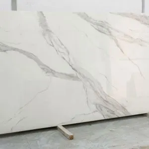 Chapa de pedra ultracompacta com veios acinzentados em fundo branco.